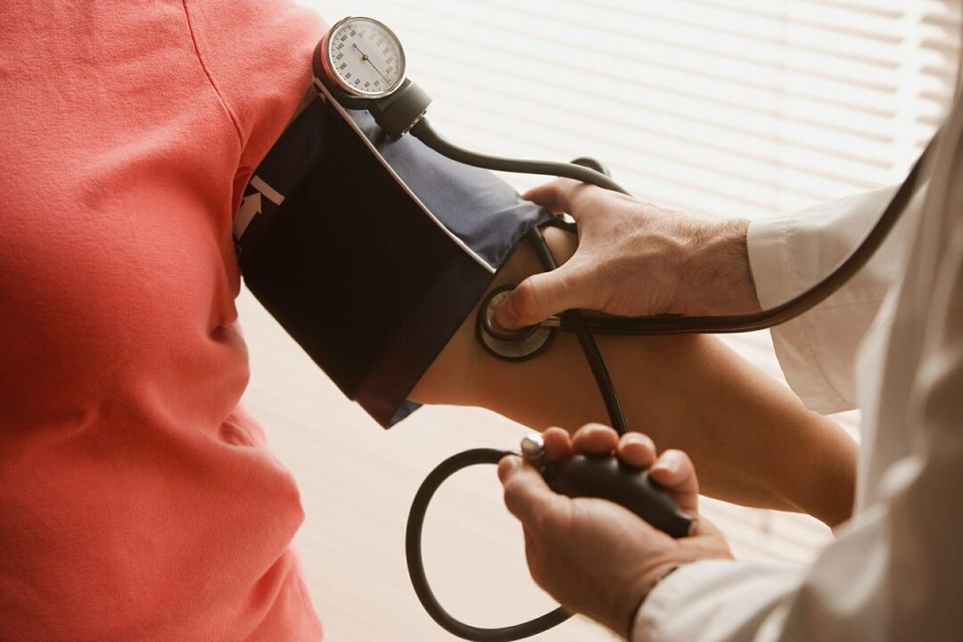 طبيب يقيس ضغط الدم لمريض يعاني من ارتفاع ضغط الدم